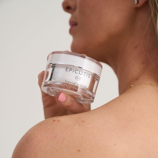 Person holding a jar of Epicutis cream against a neutral background