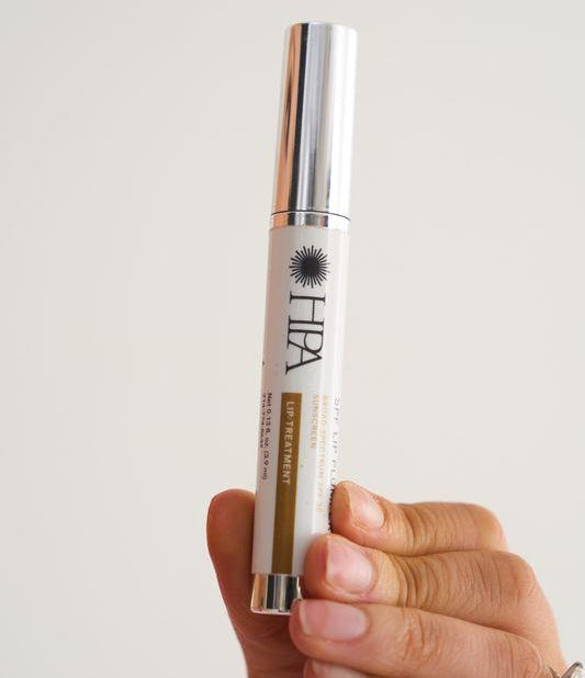 Hand holding a skincare product with a white background